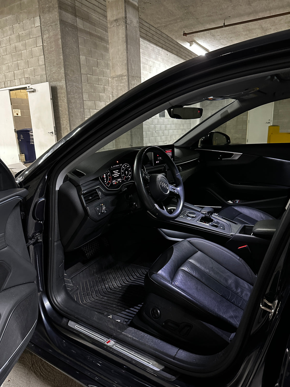 Open driver’s door of Darkhan’s Audi, showing the sill trim and seat after lighter paint repairs.