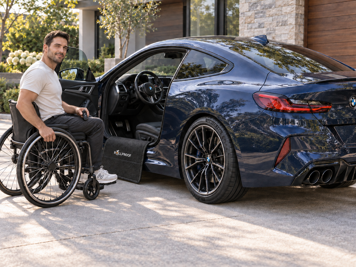 A wheelchair user beside a blue BMW coupe and RollProof Door sill protector.